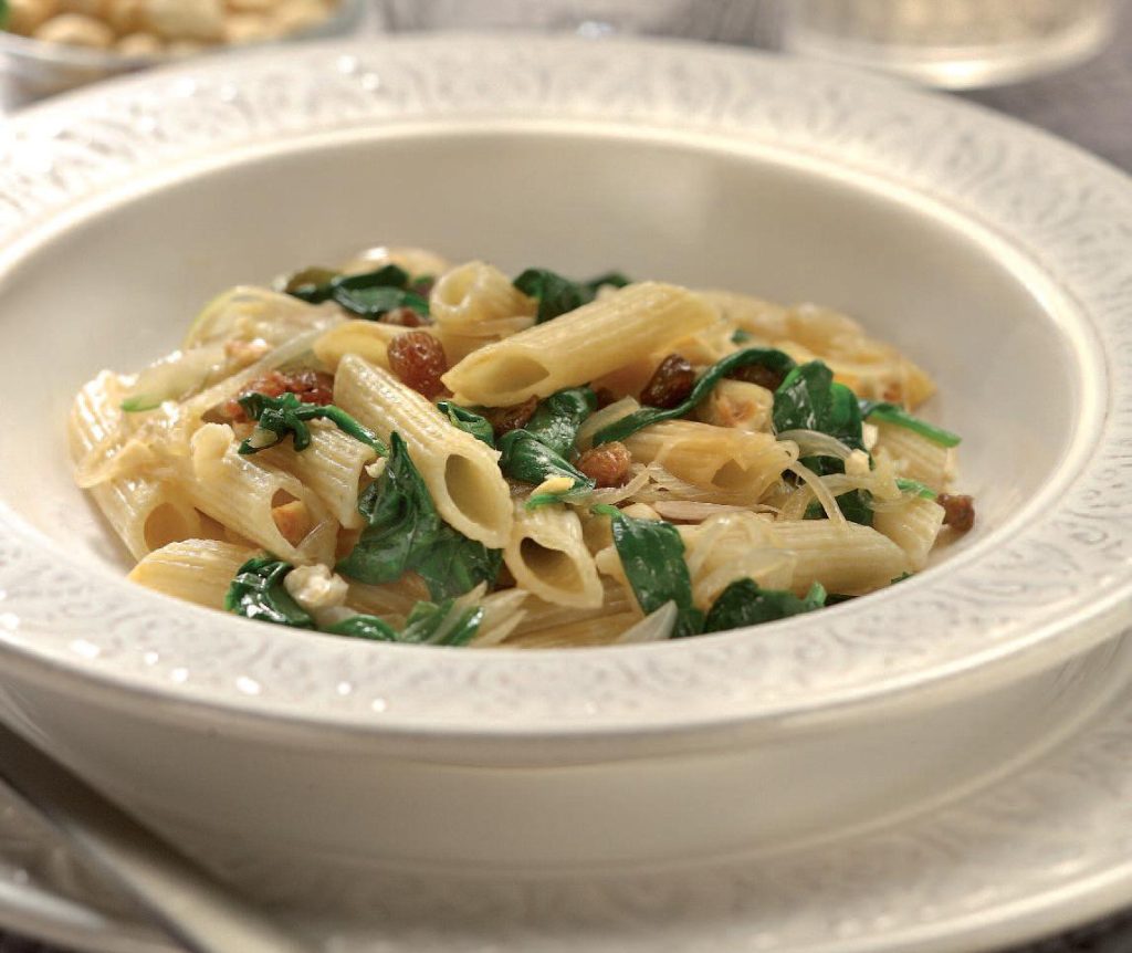 Penne con spinaci, nocciole e uvetta